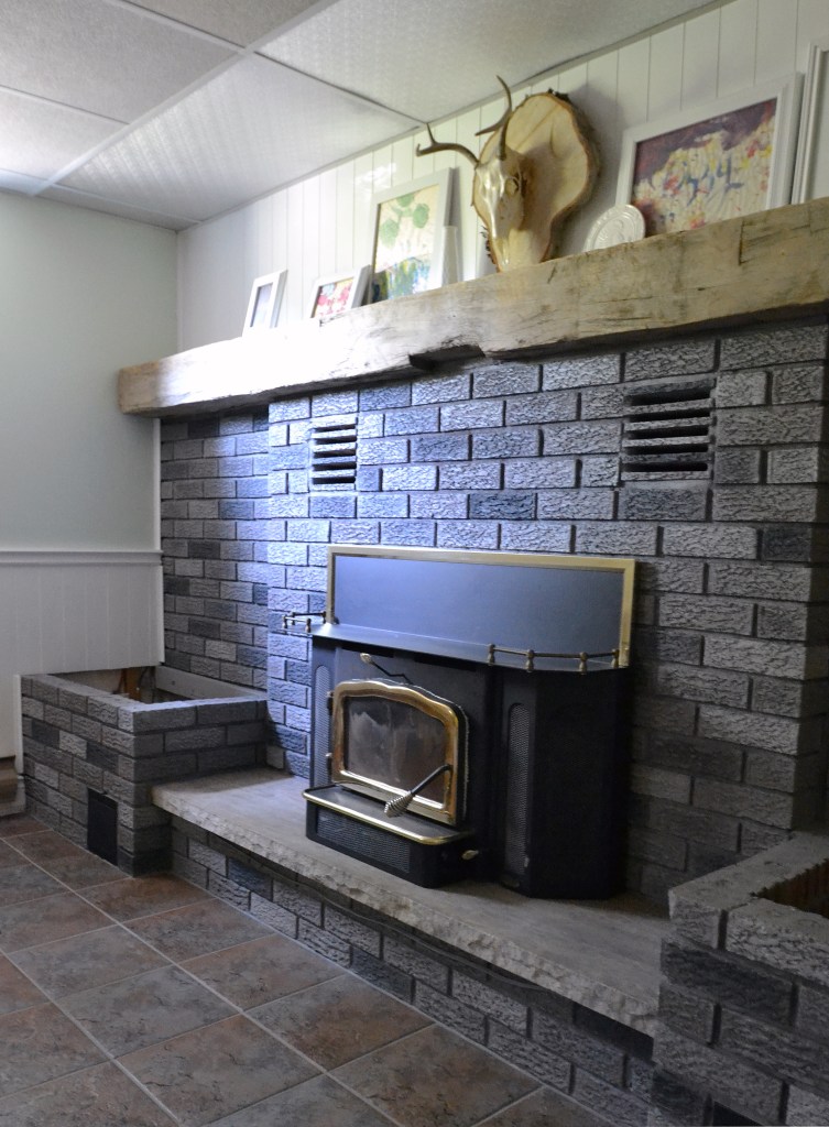 Fireplace makeover DIY with a grey paint wash on red brick.