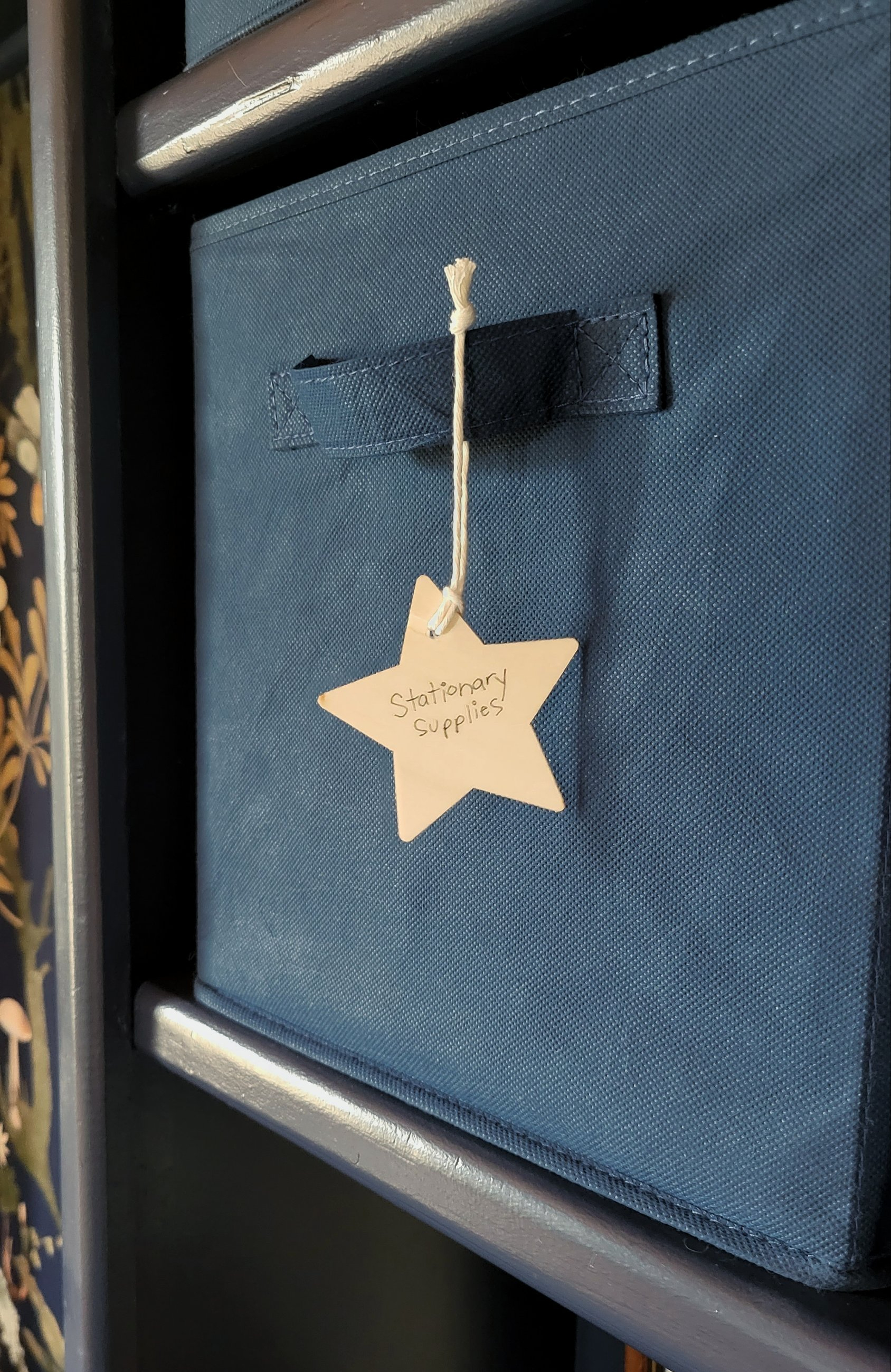 Foldable fabric basket in navy blue for art supply storage.