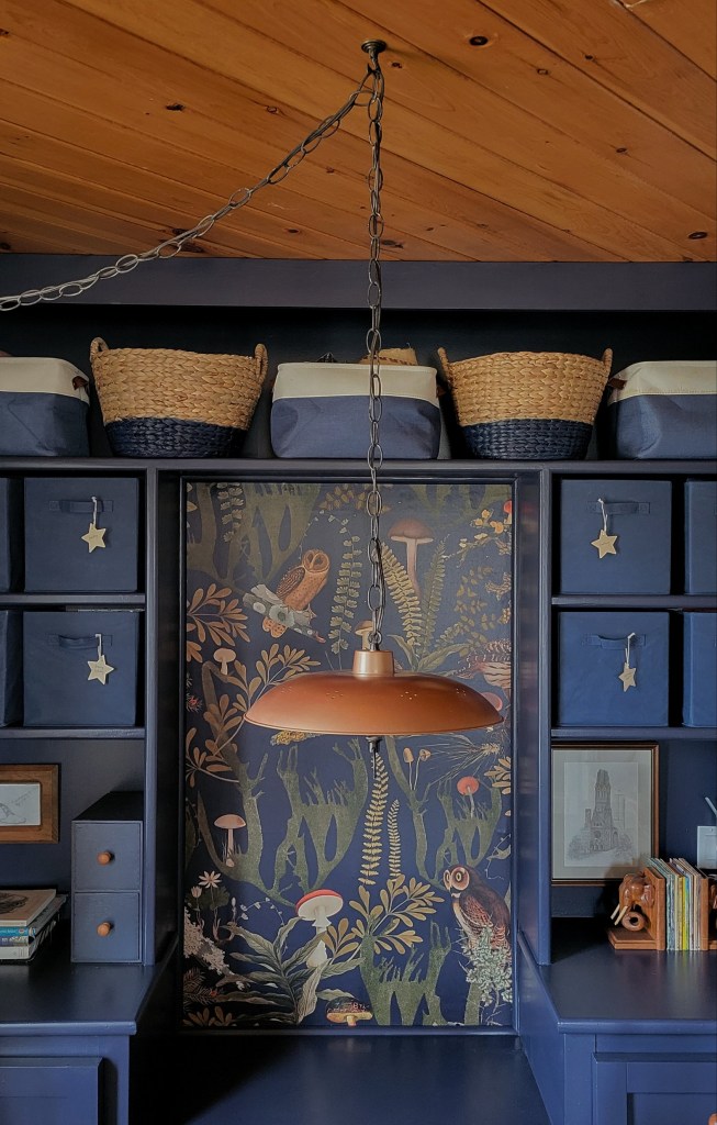 A vintage hand-made copper pendant light hangs centered in front of the art station built-in to provide task lighting.